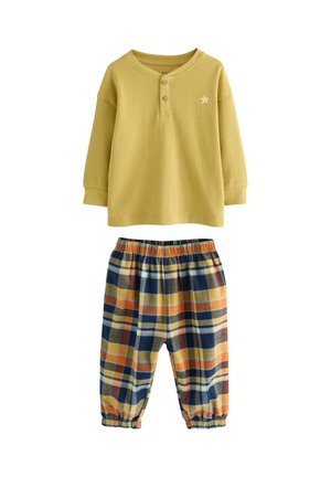 Gelbes, geripptes Langarmshirt mit Knöpfen und Sternakzent, kombiniert mit karierten Hosen mit elastischem Bund in Blau-, Gelb- und Orangetönen.