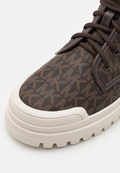 Brown patterned sneaker with a smooth leather upper, textured design, round toe, and beige rubber sole featuring deep tread for grip.