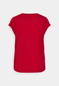 Haut rouge à manches courtes avec un col rond et une coupe ample. Fabriqué en tissu doux au toucher lisse. Présente un design simple et épuré, sans ornements.