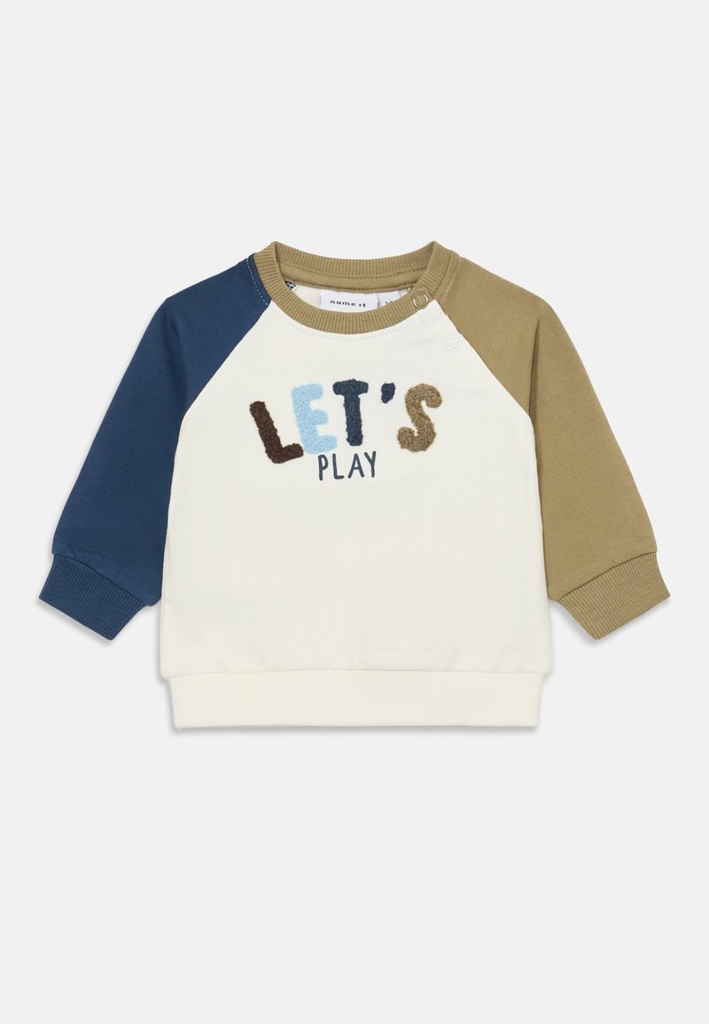 Pull-over à manches longues pour tout-petit avec manche gauche marine, manche droite olive, corps crème, et "LET'S PLAY" brodé sur le devant.