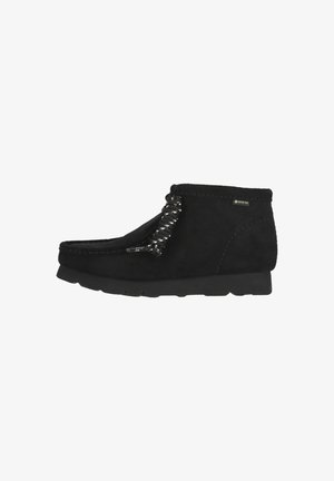 Schwarzer Wildleder-Stiefelette mit rundem Zehenbereich, einzigartigem geflochtenem Schnürdetail und einer strukturierten Gummisohle für besseren Halt. Wasserdichtes Gore-Tex-Material.