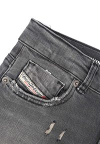 Jeans in denim grigio con finitura strappata, caratterizzati da una piccola tasca con un'etichetta logo visibile, bottone metallico e bordi sfilacciati.