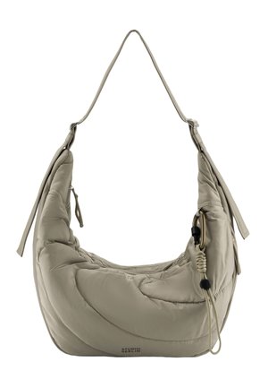 Light beige padded shoulder bag with long strap, front zipper pocket, decorative carabiner, and "Studio Berlin" logo at the bottom.