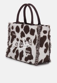 Borsa tote in feltro di lana con stampa a macchie di mucca, dotata di manici marroni scuri, dettagli in frange e testo ricamato bianco che dice "Sognando il Paradiso Invernale di Saint Barth."