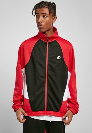 Red and black zip-up jacket with white accents, featuring a high collar, elastic cuffs, and a logo on the chest. Smooth fabric texture.