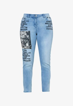 Hellblaue Jeans mit schwarzem, bedrucktem motivierendem Text auf den Taschen und dem Oberschenkel, mit einem monochromen grafischen Patch am linken Bein.