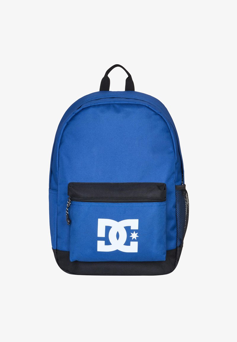 Blue fabric backpack with black bottom, front zip pocket, and a large white DC logo. Features a top handle and side mesh pocket.
