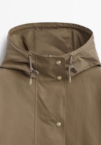 Brown hooded jacket featuring a cinched neck, smooth texture, zip closure, and metallic buttons for fastening.