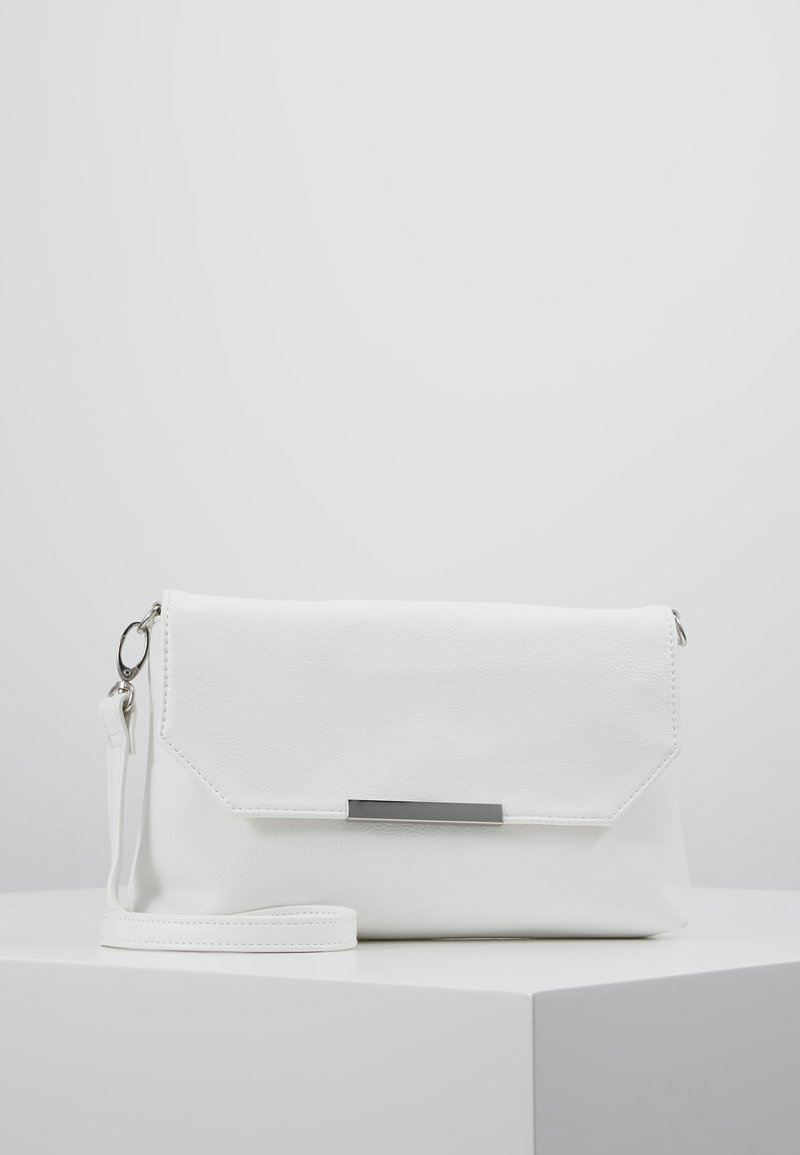 Pochette en cuir blanc avec bandoulière poignet et accent métallique rectangulaire argenté sur le rabat avant, posée sur une surface blanche sur fond gris clair.
