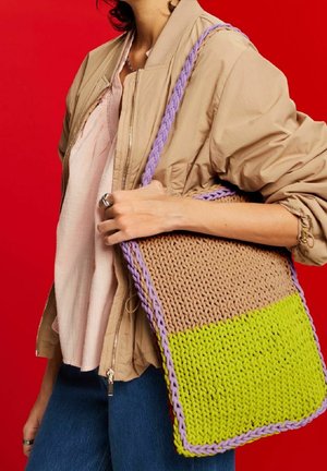 Borsa tote lavorata a maglia colorata con una sezione superiore marrone e una inferiore verde brillante, accentuata da manici intrecciati viola. Materiale tessuto e strutturato.