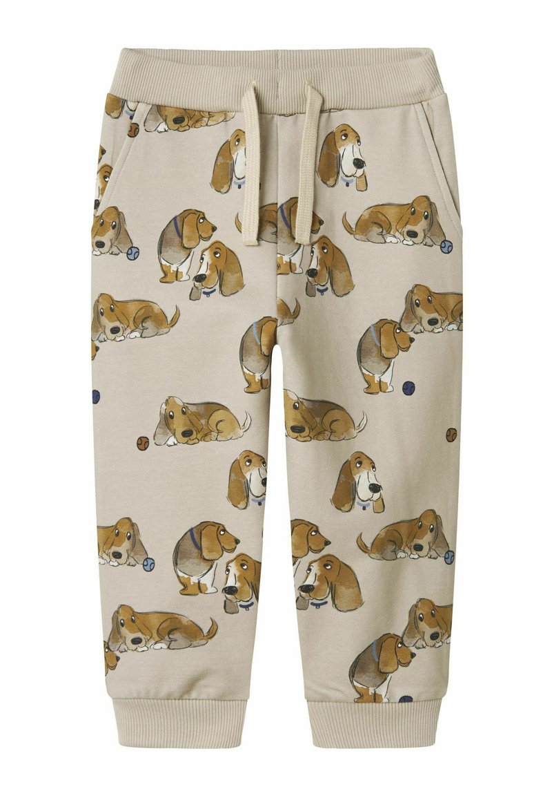 Beige sweatpants met een herhaald basset hound patroon in verschillende poses. Materiaal: zachte stof; elastische tailleband en manchetten.