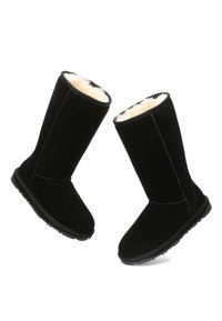 Black suede knee-high boots with a soft fur lining, flat rubber sole, and stitched detailing along the seams.