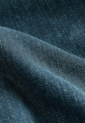 Tumesinine denimpind, millel on tekstuurne kudumine, näidates peeneid värvimuutusi ning pehmet, kergelt tekstuurset välimust.