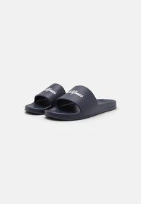 Sandales en slide navy avec un design ouvert à l'avant courbé. Dessus synthétique lisse avec texte de logo blanc. Semelle intérieure texturée pour une adhérence.