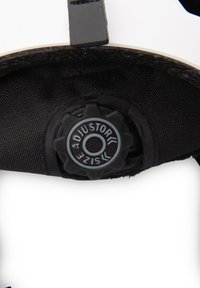 Helm detail met een zwarte afstelknop met een getextureerd oppervlak, voor een witte helmvoering met een geweven zwarte stoffen achtergrond.