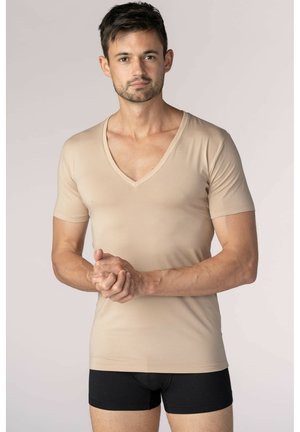 Beige V-neck short-sleeve t-shirt made from smooth fabric, fitted design, worn with black briefs. Displays a simple, clean look.