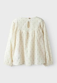 Blusa color crema con motivo floreale, dettagli arricciati sulla spalla, maniche lunghe e chiusura a oblò sul retro, con un bottone.