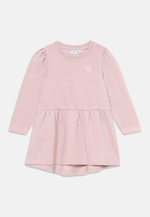 Rózsaszín, hosszú ujjas baba ruha, fodros derékkal és kis szív hímzéssel a mellrészen, puha pamut anyagból készült.
