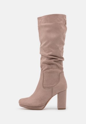 Botte en daim taupe montant jusqu'au genou avec une tige souple, un bout rond, une semelle plateforme et un talon haut épais.