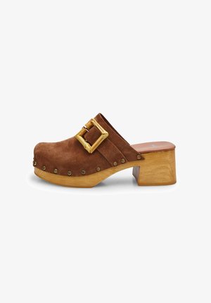 Brown suede clog featuring a wooden heel, a wide strap with a square buckle, and metallic studs along the front edge.
