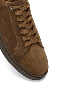 Sneaker in suede marrone con punta arrotondata, tomaia testurizzata e lacci marroni. La suola è scura e leggermente rialzata.