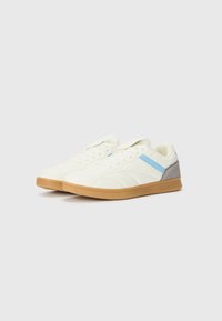 Adidași albi cu accente bleu deschis și gri, suprafețe texturate și talpă din cauciuc. Design cu șireturi, limbă căptușită și guler cu pernite.