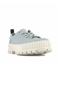 Baskets en toile bleu clair avec semelle en caoutchouc blanche, présentant une base texturée et striée ainsi qu'un onglet de talon noir. Design classique à lacets.