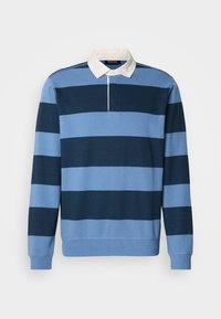 Pull en polo rayé bleu et marine avec col blanc, manches longues et poignets côtelés. Fabriqué en coton doux, doté d'une patte de boutonnage demi-longue.