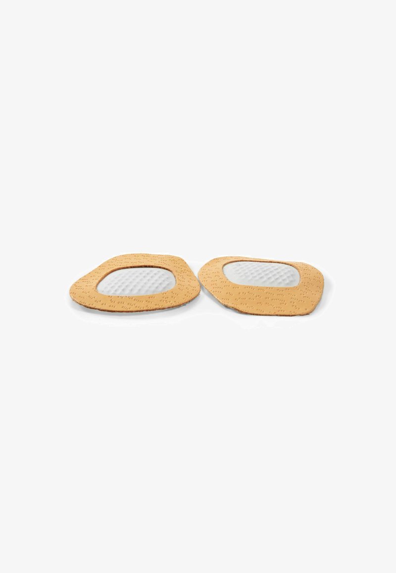 Two tan-colored foot pads with textured outer edges and white mesh centers, designed for cushioning and support. Shape is irregular and flat.