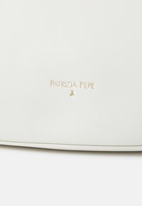 Sac à main en cuir blanc texturé avec une finition lisse. Possède un logo en relief doré et un design minimaliste, mettant en avant des lignes épurées.