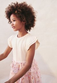 Lichtroze jurk met ruches aan de korte mouwen, voorzien van een bloemenpatroon op de rok met gelaagde ruches, gemaakt van een lichtgewicht stof.