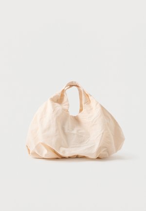 Béžová opakovane použiteľná taška z textilu s zaobleným tvarom a integrovanými krátkymi rúčkami, zobrazená na jednoduchom bielom pozadí.