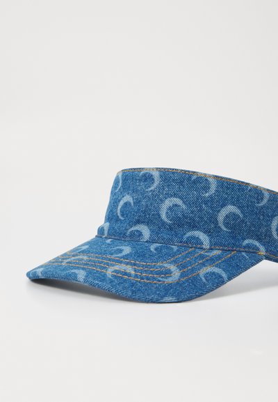 Denim visor cap featuring a blue base with a lighter blue abstract pattern, curved peak, and contrasting stitching along the edges.