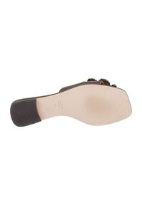 Suela de sandalia marrón con patrones texturizados y una ligera curva. La parte inferior presenta una sección suave beige con marcas de la marca.
