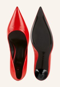 Escarpins rouges à bout pointu en cuir brillant, avec une semelle et un intérieur noir, arborant un design minimaliste. Aucun matériel visible ni motifs.