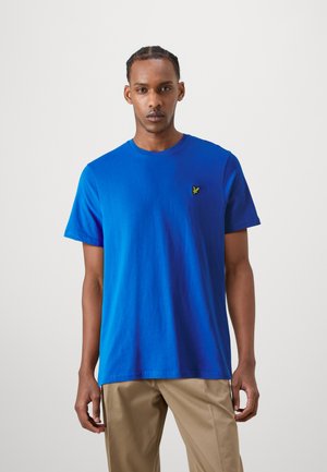 Camiseta de algodón azul con mangas cortas y cuello redondo. Presenta un pequeño logotipo bordado en verde en el lado izquierdo del pecho.