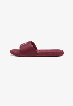 Vinrød Puma slide-sandal med en enkelt bred rem, tekstureret fodseng og Puma-logo på remmen og på siden af sålen.