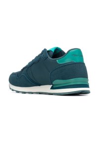 Sneaker di un verde scuro in tessuti misti, tra cui suede e rete. Presenta una suola intermedia bianca, accenti turchesi e un tallone testurizzato.
