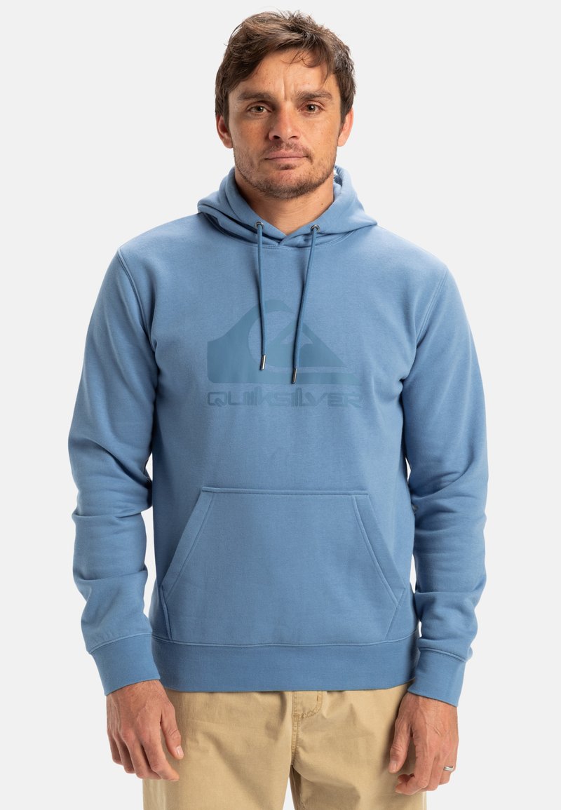 Blå hoodie med framficka och en stor logotyp på bröstet. Mjuk tygkvalitet med avslappnad passform och långa ärmar.