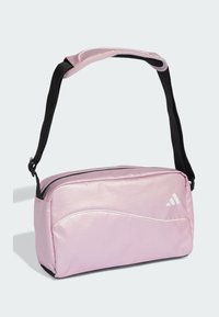 Pink synthetic crossbody bag with black strap, featuring a curved white design accent and branded logo in white on the front.