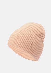 Mjukt rosa ribbat stickad mössa med uppvik, visad från en vinkel mot en vit bakgrund.