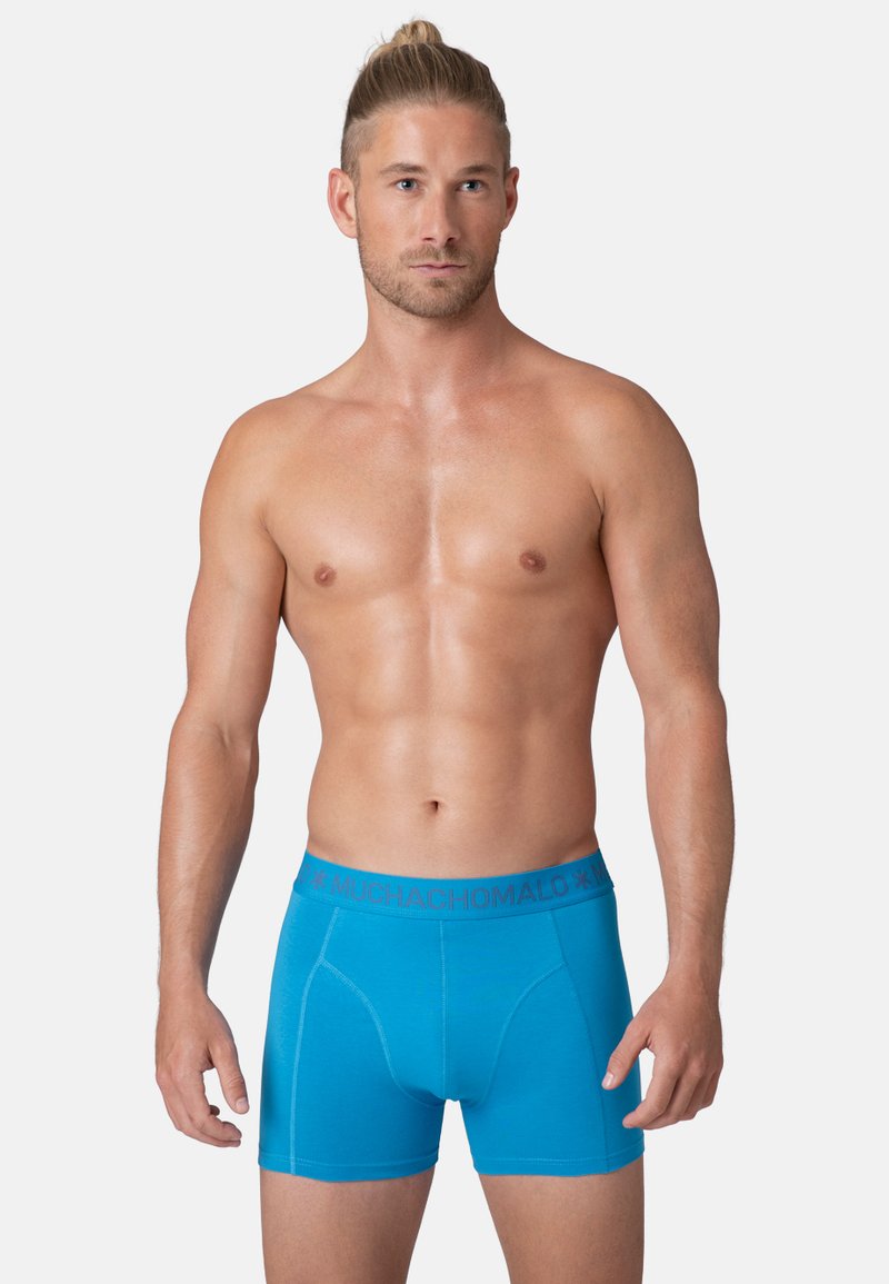 Boxers en tissu bleu vif avec une texture douce, dotés d'une ceinture grise avec logo et d'une coupe ajustée pour le confort et le soutien.