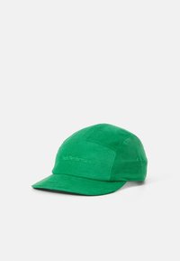 Green corduroy cap with a curved brim, featuring "PeakPerformance" logo embroidered on the front. Textured material and structured design.