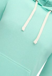 Hooded sweatshirt in licht muntgroen stof, met een voorzak in kangoeroevorm en contrasterende witte trekkoorden. Gladde textuur.
