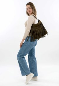 Fringe bag in dark olive suede with a spacious design. Features long, textured fringes and a single shoulder strap for easy carrying.