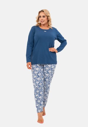 Niebieska bluzka z długim rękawem i okrągłym dekoltem w połączeniu z jasnoniebieskimi spodniami w kwiatowy wzór. Materiał wydaje się miękki i wygodny.