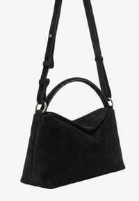Sac à main en daim noir avec une bandoulière réglable et une poignée arrondie, avec une fermeture à rabat triangulaire.