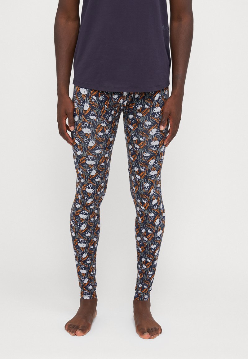 Leggings with a navy background featuring a vibrant skull and foliage print in white, orange, and green. Made from a stretchy fabric.