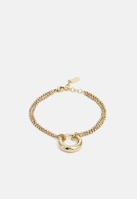 Bracciale in oro con due filamenti textured, un accento metallico circolare al centro e una chiusura con un piccolo tag.