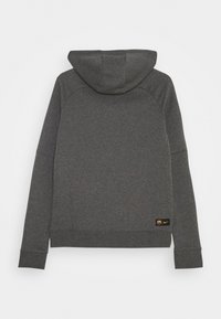 Sudadera con capucha de color gris oscuro, con una tela texturizada, capucha centrada y puños acanalados. Presenta un pequeño logo bordado en la parte inferior izquierda.